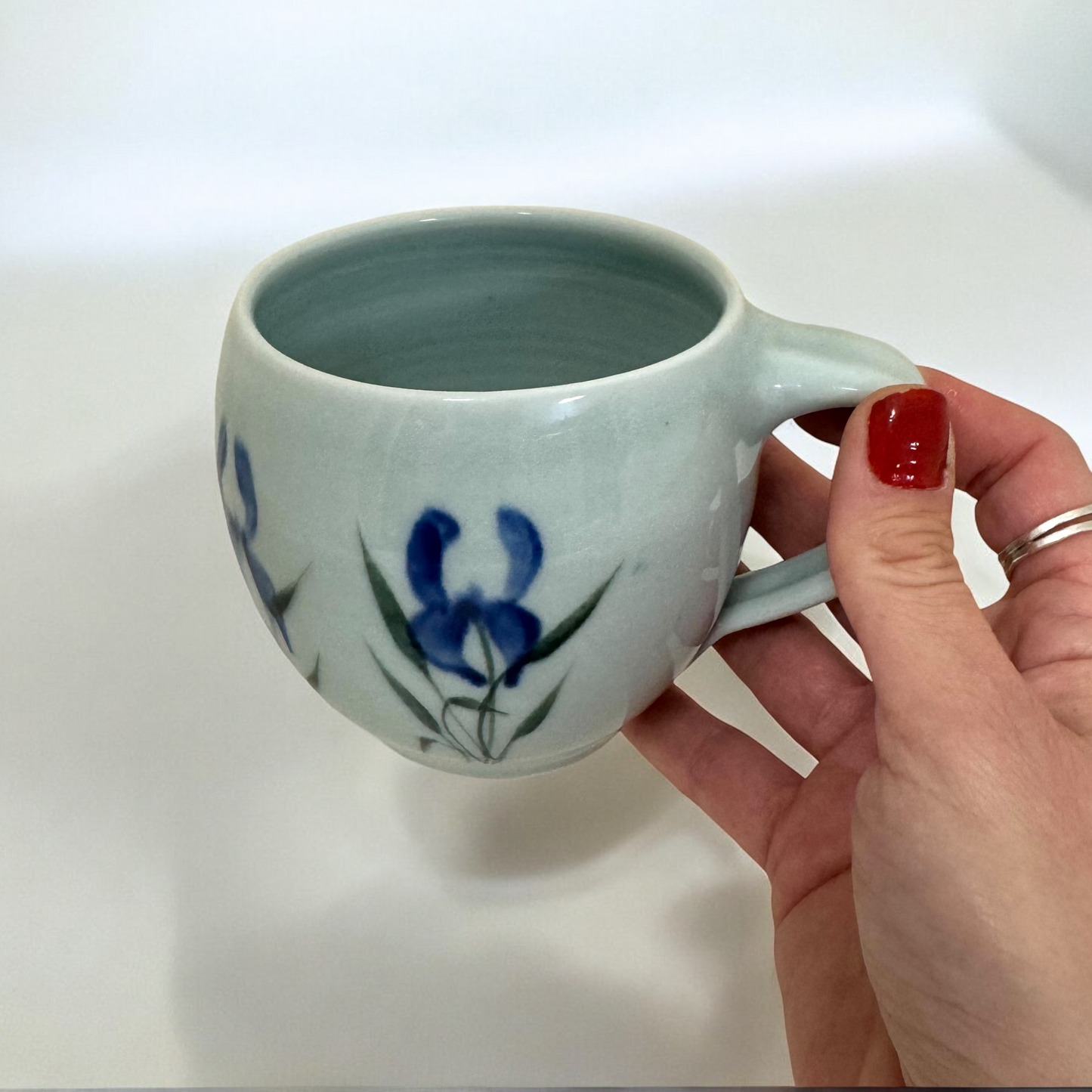 Susan_Bogen_Blue_Iris_Mug_held_in_hand_for_scale_Mug
